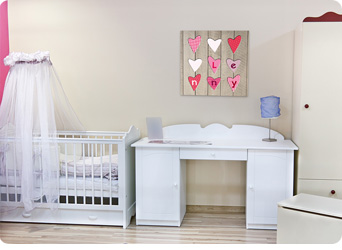 Foto van geboortekaartje als schilderij in baby kamer meisje.