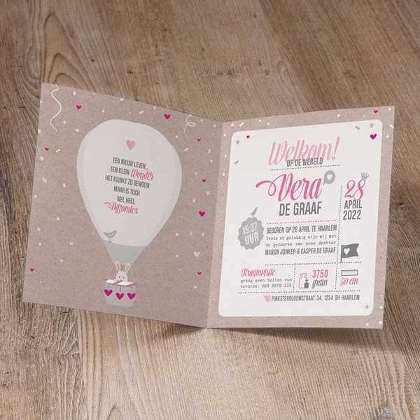 Lieflijk geboortekaartje met stoere luchtballon en roze/wit touwtje